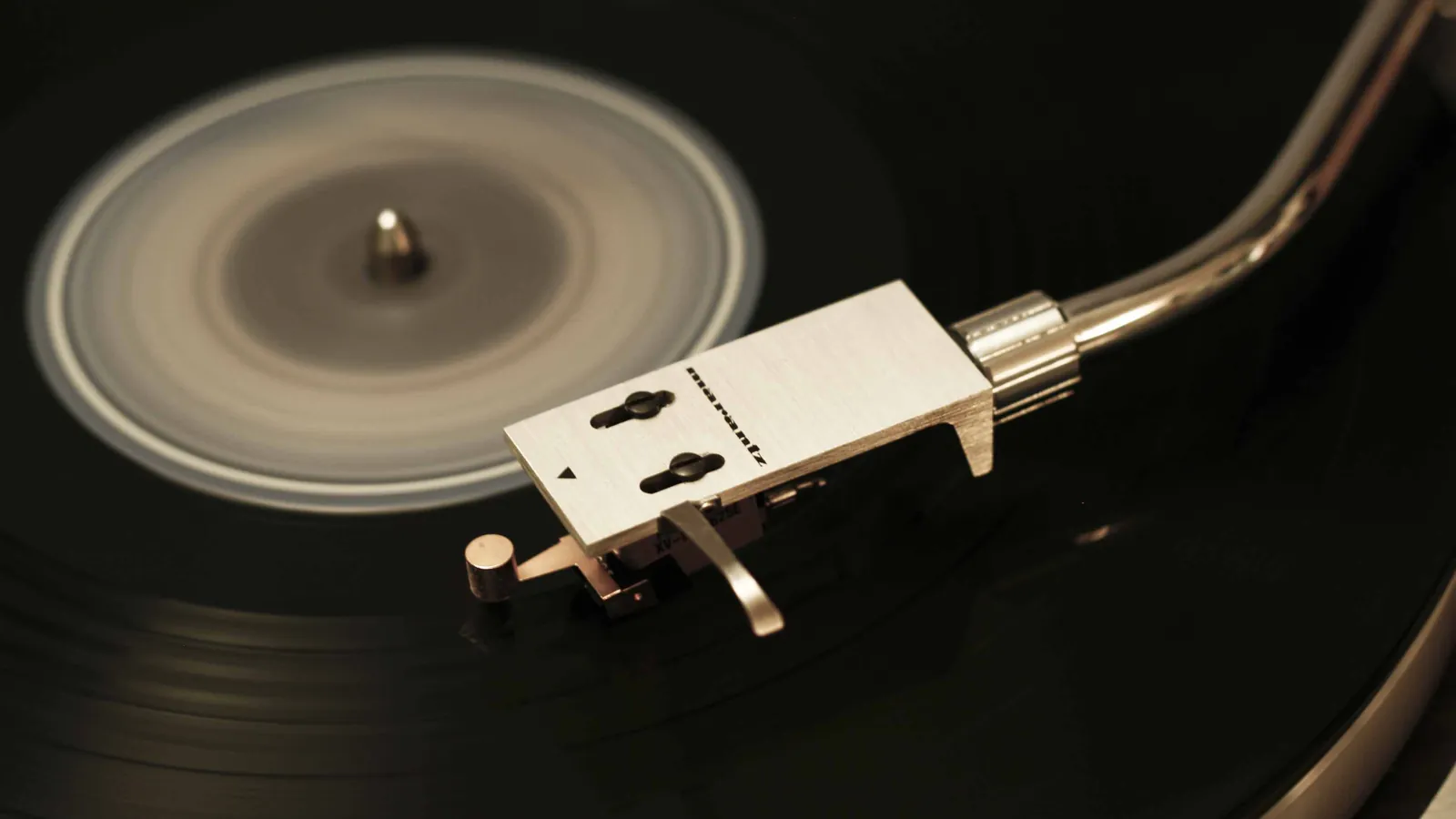 Close-up of a black vinyl record and tonearm on a turntable