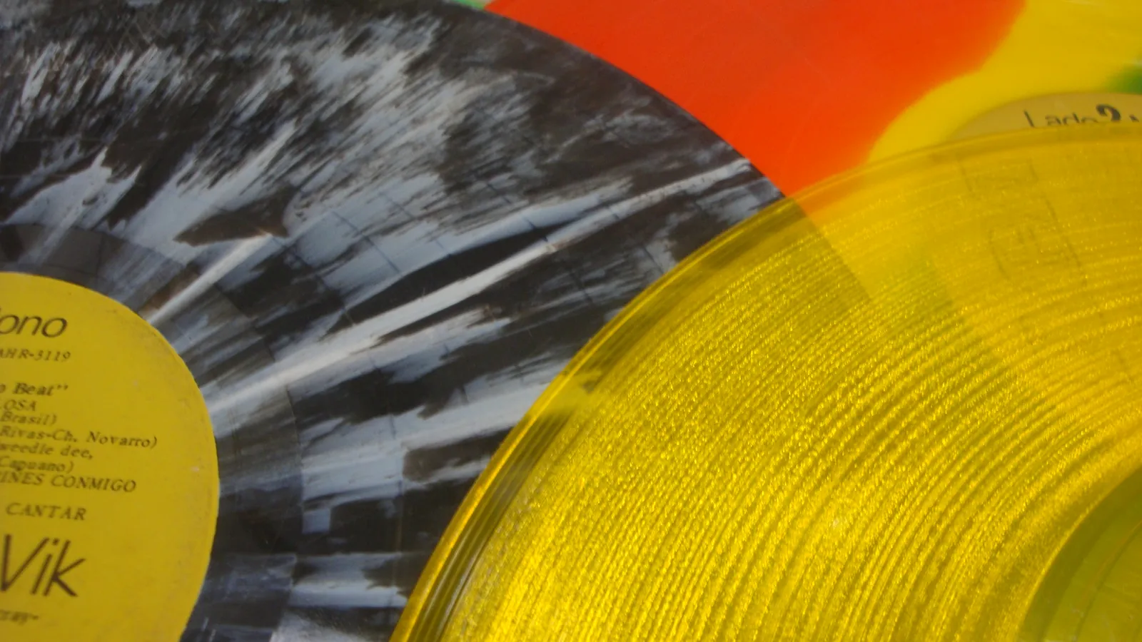 A collection of colourful vinyl records fanned out to show their different colours